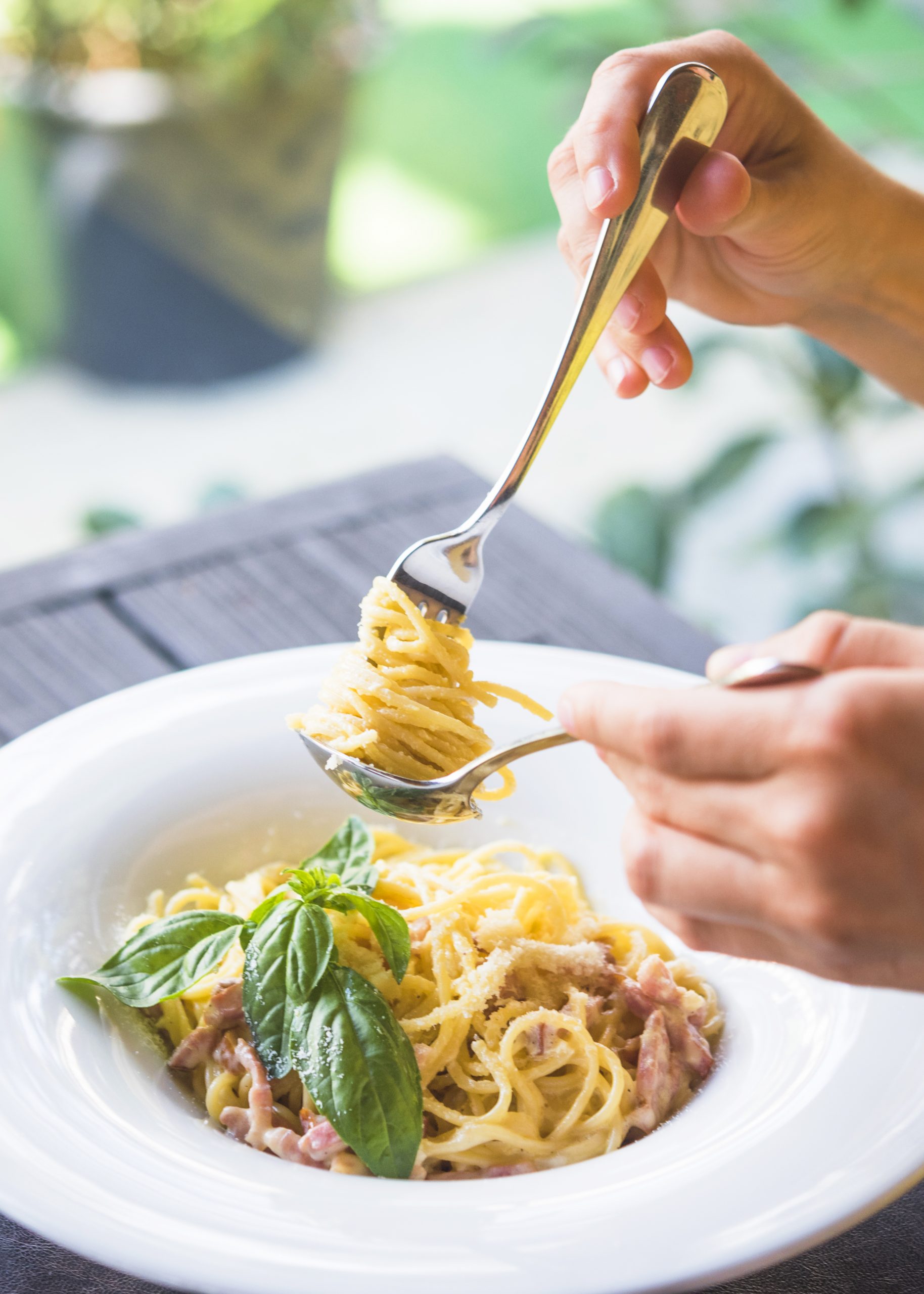 close-up-person-holding-appetizing-spaghetti-rolled-fork-spoon